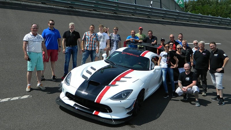 Ein Gruppenfoto mit einem Sportwagen bei einem PKW Fahrsicherheitstraining.