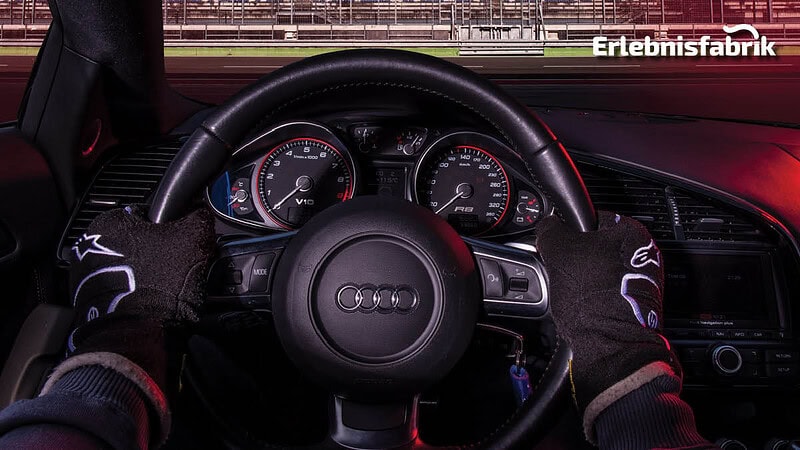 Sicht des Fahrers aus dem Audi R8 mit dem Lenkrad fest im Griff.