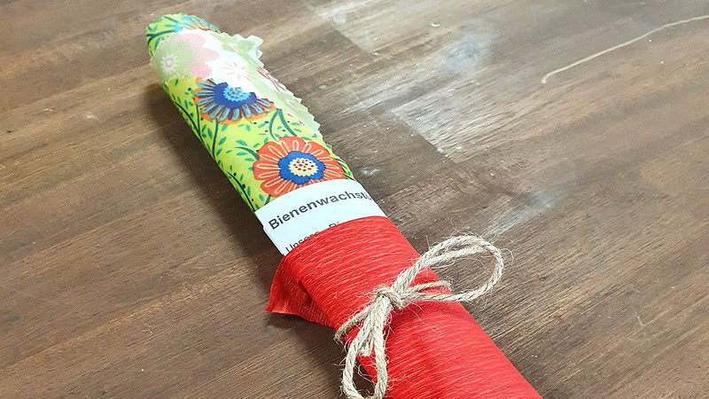 Ein eingepacktes Bienenwachstuch, das auf einem Tisch liegt.