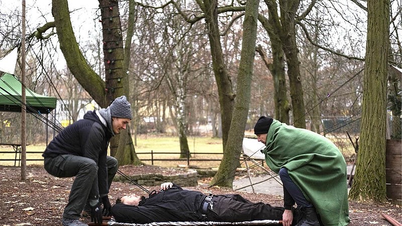 Zwei Männer beim Trage heben.