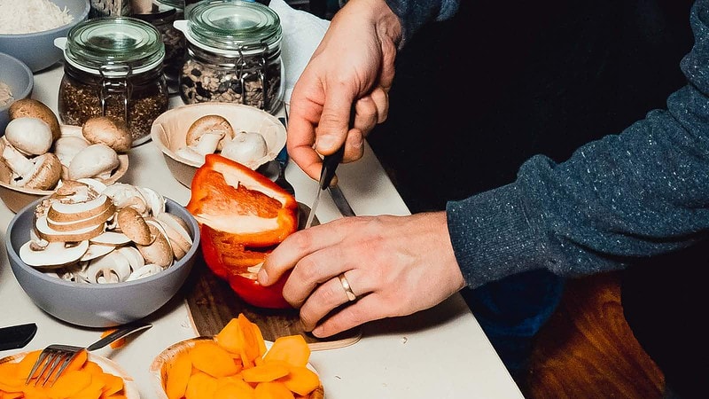 Ein Mann schneidet eine Paprika.