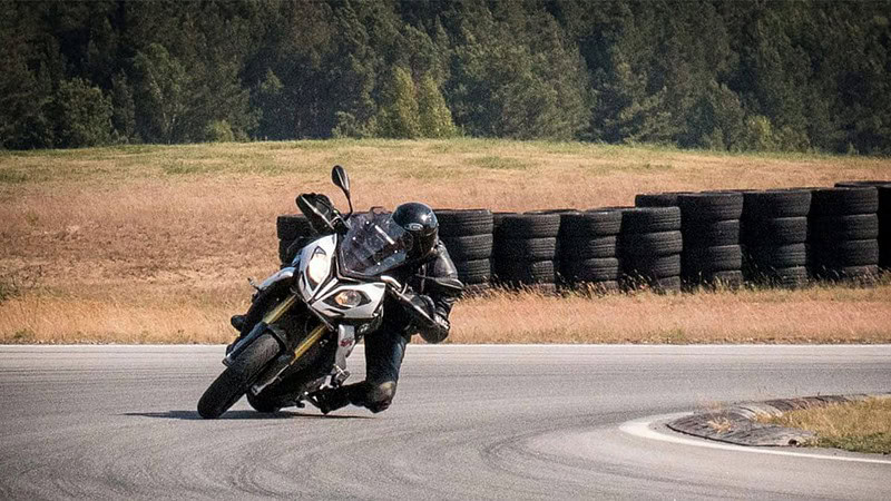 Motorradfahrer in schneller Fahrt durch eine Kurve.