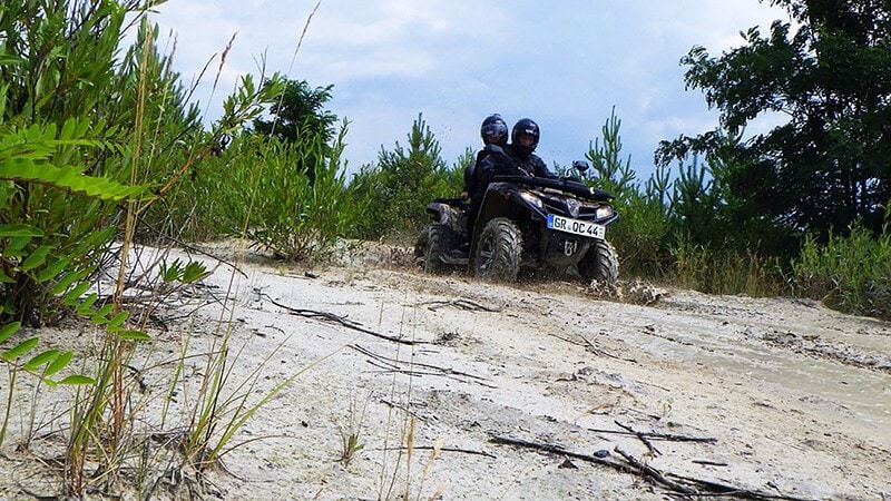 Ein Fahrer mit Beifahrer fahren mit einem schwarzen Quad eine Hang runter - Entdecker Tour Oberlausitz.