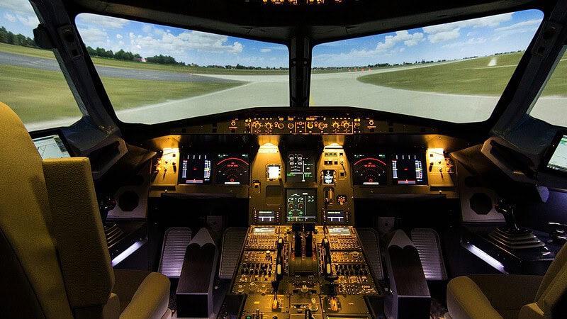 Originalgetreues Airbus-A320-Cockpit mit leuchtenden Displays und Runway-Simulation, zwei Sitze und bedienbare Instrumente.
