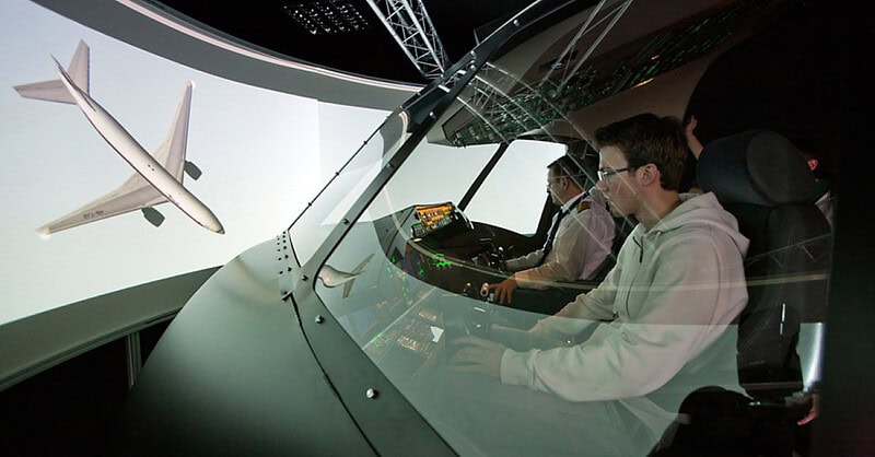 Blick auf zwei Hobbypiloten in einem Flugsimulator.
