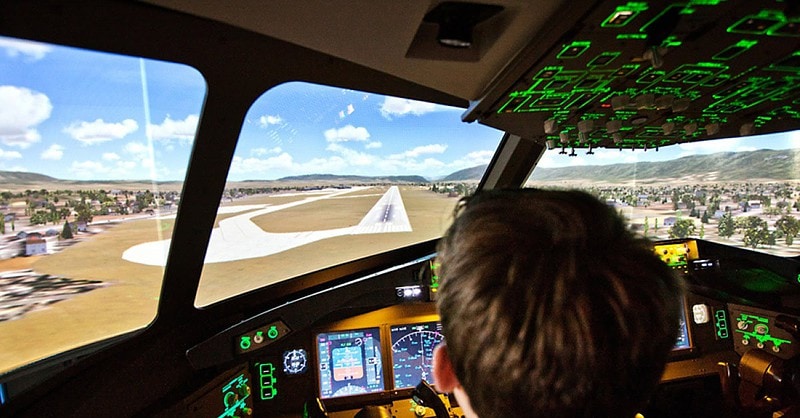 Blick über die Schulter eines Hobbypiloten beim Landeanflug im Flugsimulator.