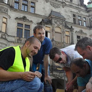 Männer finden einen Geocach bei der Team Challenge Schnitzeljagd