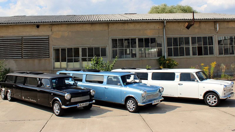 Drei Trabant-Stretchlimousinen stehen auf einem Hof.