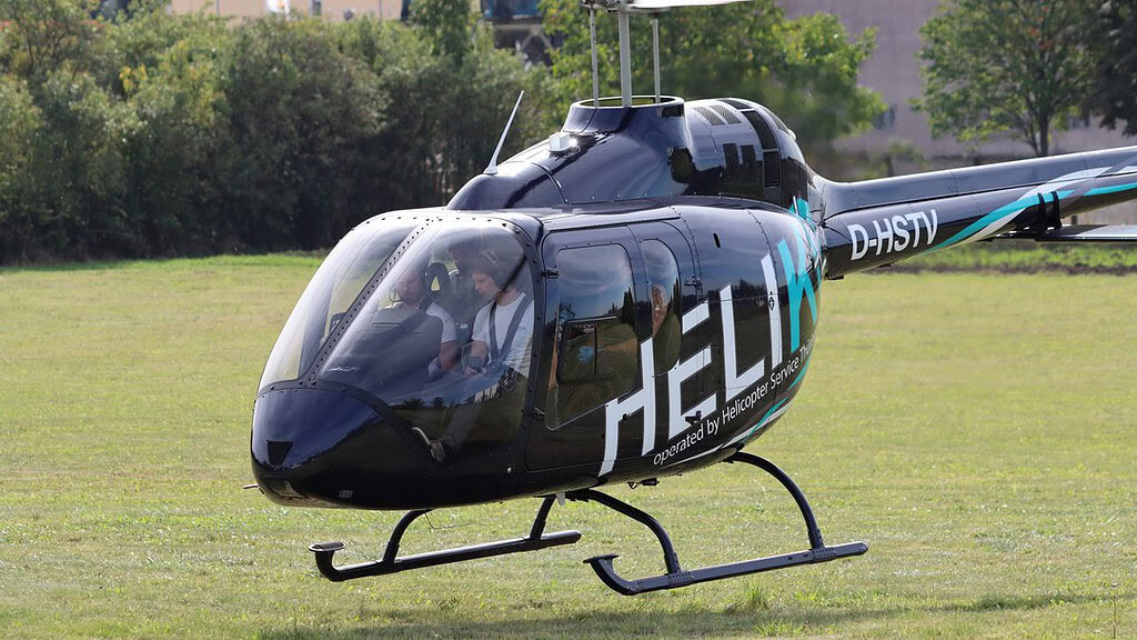 Ein Helikopter mit vier Personen ist im Aufstieg.