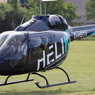 Ein Helikopter mit vier Personen ist im Aufstieg.