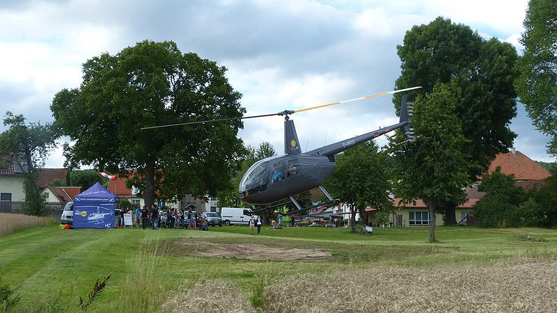 Ein grauer Hubschrauber steigt in die Luft.