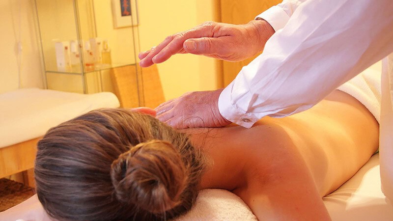Mann massiert Frau den Rücken mit einer Lomi Lomi Massage in Dresden