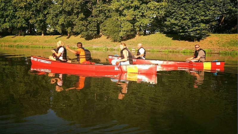Zwei Kanus auf dem Wasser mit Insassen bei einer Quad Kanutour.