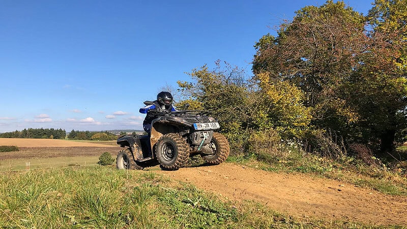 Ein Teilnehmer der Quad Offroad Tour bei Möckmühl fährt mti einem Quad einen Hügel rauf.