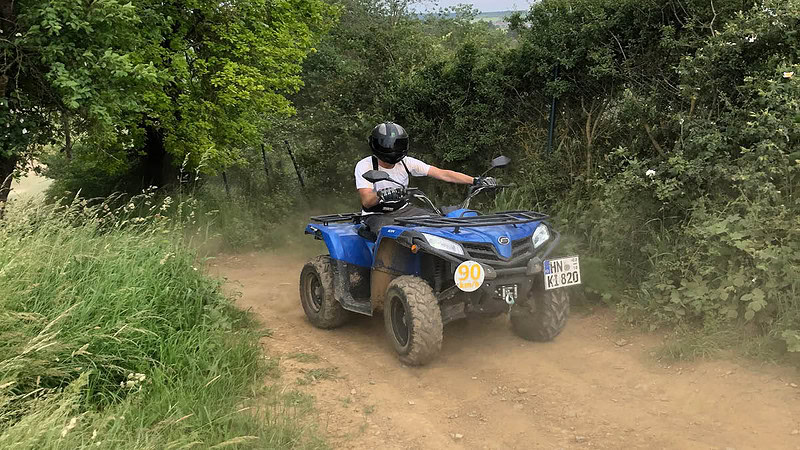 Ein Teilnehmer einer Quad Tour fährt auf seinem Quad einen Feldweg entlang.