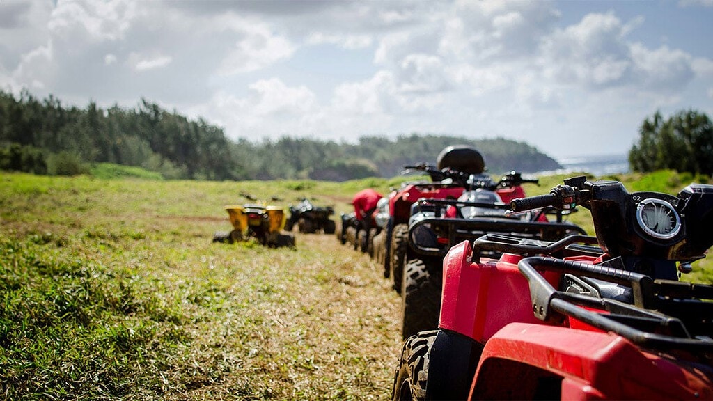 Mehrere rote Quads stehen auf einem Feld in einer Reihe.