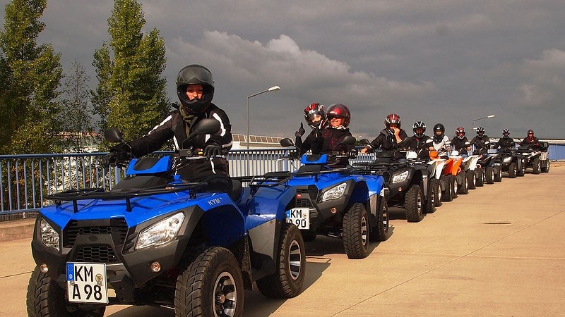 Zehn Personen stehen Schlange mit ihren Quads und sind bereit für die Quad Tour.