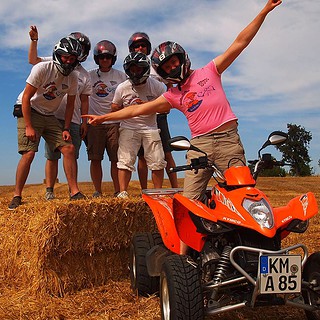 Die Teilnehmer einer Quad Tour posieren vor einem Quad für ein Bild.