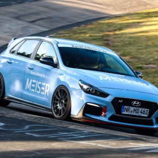 Ein blauer Hyundai Rennwagen in einer Kurve auf einer Rennstrecke.