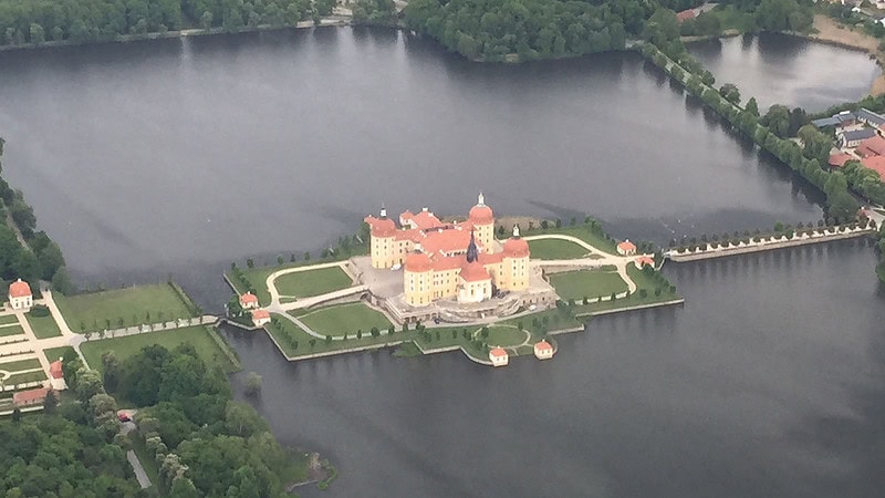 Das Flugzeug überfliegt das Schloß in Moritzburg.