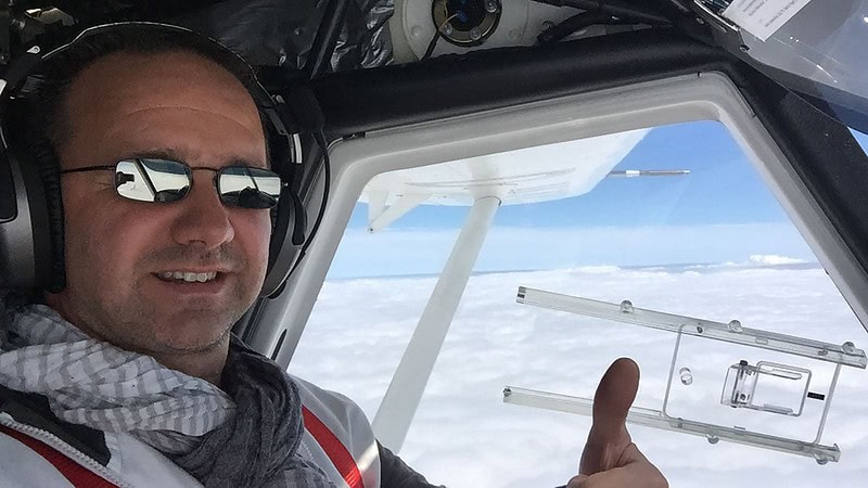 Ein Mann zeigt mit seinem linken Daumen beim Rundflug über die Oberlausitz, dass ihm der Flug gefällt.