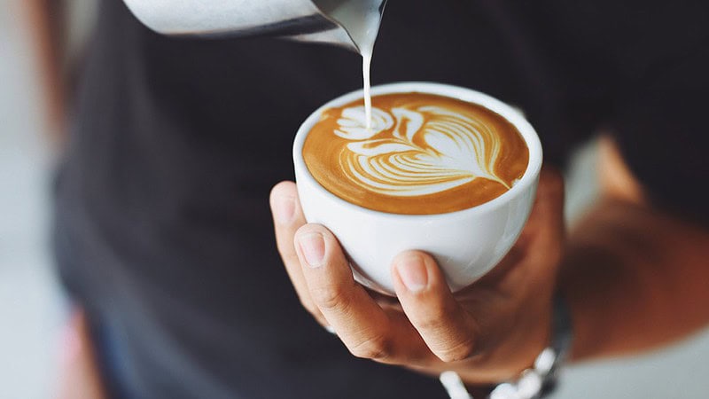 Man sieht jemanden der Milch in eine Tasse Kaffee kippt- Sensorikkurs Mini in Dresden