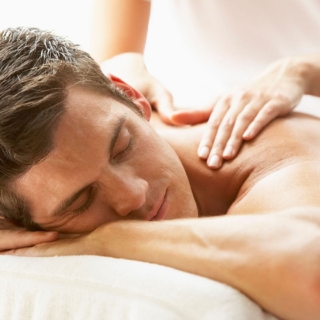 Ein Mann genießt eine Rückenmassage.- Ganzkörpermassage