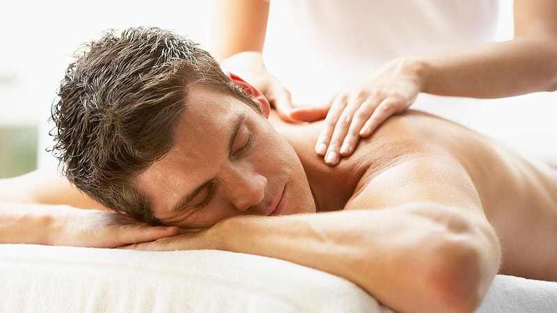 Ein Mann genießt eine Rückenmassage.- Ganzkörpermassage