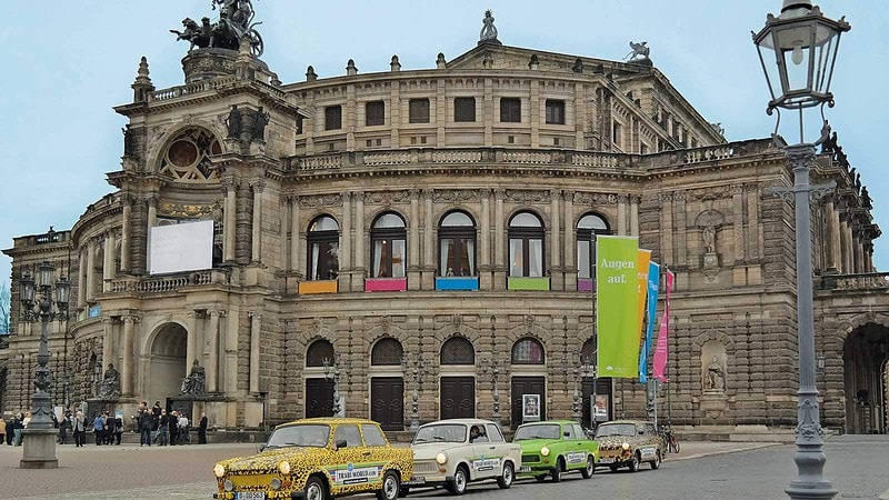 Vier Trabis stehen in einer Reihe vor der Semper Oper in Dresden.