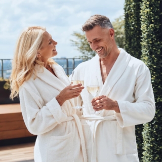 ein älteres Paar genießt einen Wellness-Tag und trinkt Champagner