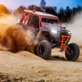 Buggy fährt im Gelände und hinterlässt eine Rauchwolke