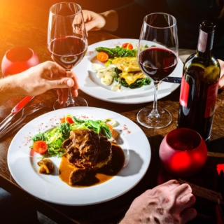 üppiges Abendessen mit Rotwein in einem Restaurant, von oben fotografiert