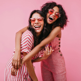 2 Frauen posieren zusammen für ein Fotoshooting und lächeln