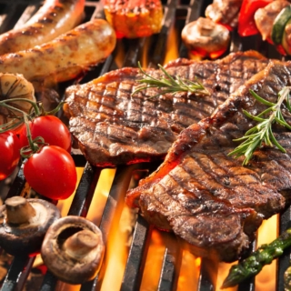 verschiedene Fleisch- und Gemüsesorten werden auf dem Grill gegrillt