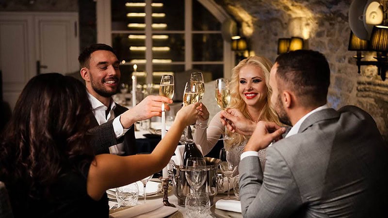 Vier schick gekleidete Personen beim Essen auf einer kulinarischen Stadtführung.