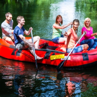 Eine Gruppe von Freunden fährt mit einem Schlauchboot zusammen