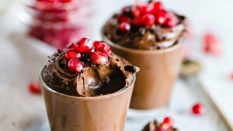 Schokoladendessert in Bechern, dekoriert mit Granatapfelfrüchten