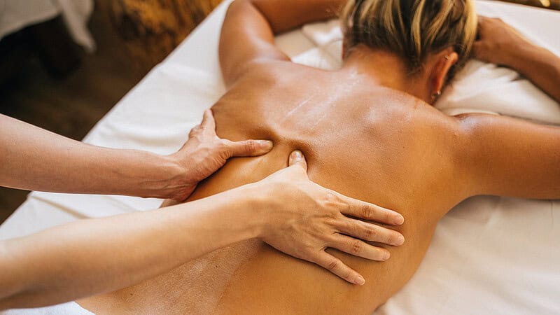 Einer Frau wird der Rücken mit ARomaöl massiert