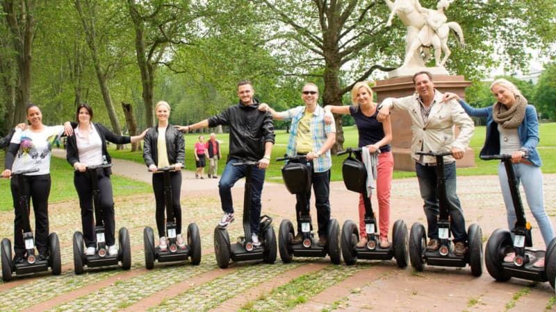 Eine Gruppe von Segway-Fahrer posiert für ein Gruppenfoto im Park in Stuttgart.
