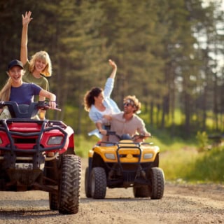 4 Personen fahren auf 2 Quads durch den Wald während einer Quad Tour.