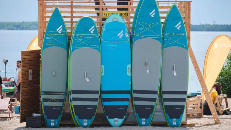 stand up paddle Boards stehen an einem Rettungsturm angelehnt
