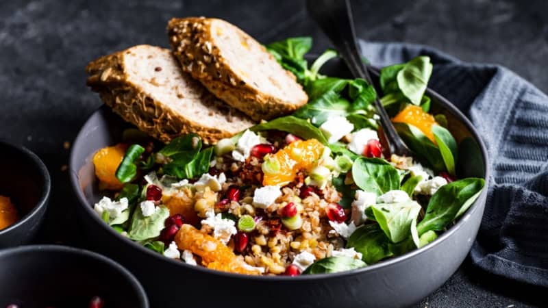 Vegetarischer Salat mit Ziegenkäse, Hülsenfrüchten und Brot.