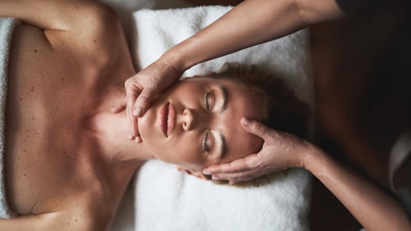 Eine Frau erhält eine beruhigende Gesichtsmassage.