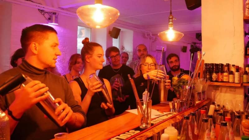 Eine Freundesgruppe mischt Cocktails bei einem Cocktail Workshop in einer Bar in Frankfurt.