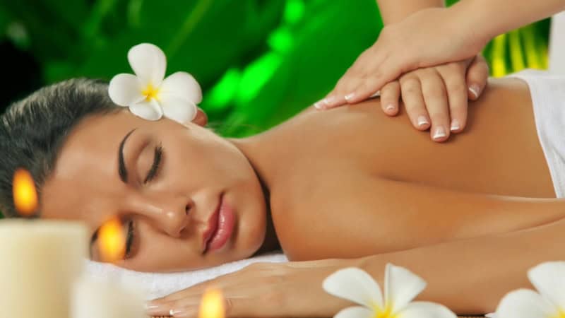 Frau auf einer Massageliege bei der Rückenmassage.