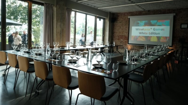 In einem Seminarraum stehen Tische in U-Form gedeckt und bereit für die Weintasting Gameshow in Stuttgart.
