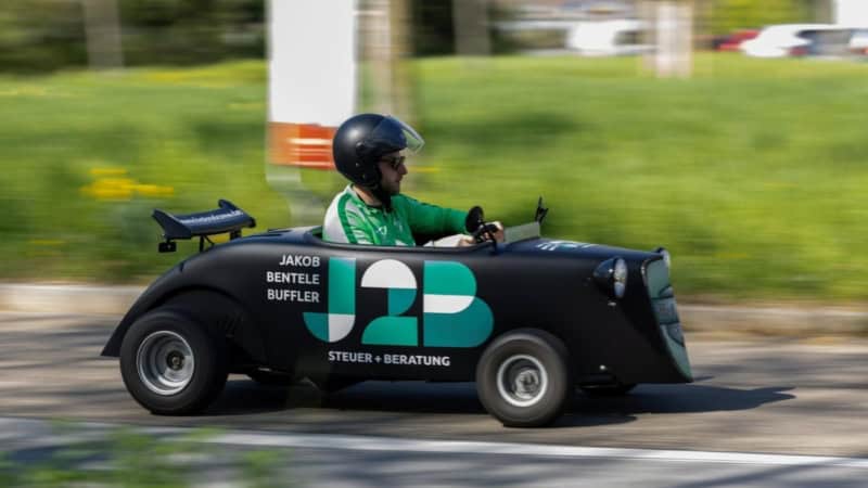 Ein Hotrod Fahrer der sehr schnell über eine Straße bei einer Hotrod Tour fährt.