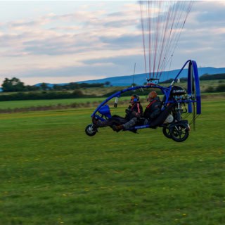 Ansicht von rechts beim Trike Drachen Rundflug, Personen sitzen drin.