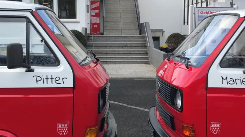 2 rote VW Bullies stehen sich frontal gegenüber.